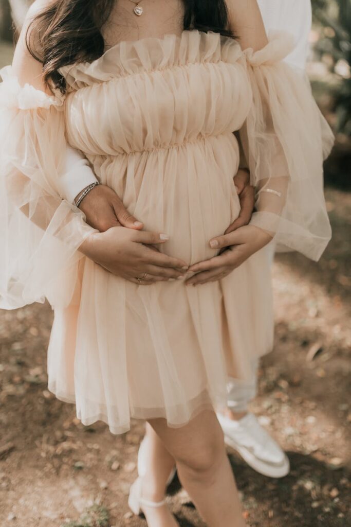 A beautiful maternity photo with a focus on the expectant mother, surrounded by soft light and nature.