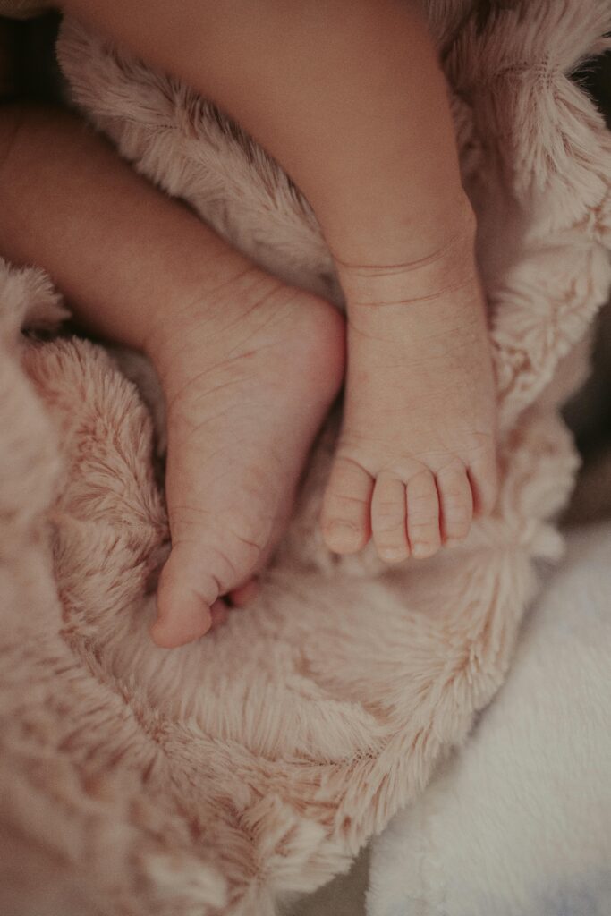 Close-up of tiny baby feet nestled on a soft, fluffy blanket. Perfect for nursery decor.